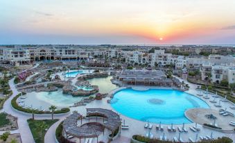 aerial view of a resort with multiple pools and a golf course in the background at Kempinski Hotel Soma Bay