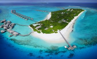 aerial view of a tropical island with white sand beaches , blue water , and lush green vegetation at Six Senses Laamu