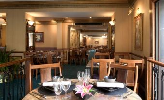 a dining room with tables and chairs arranged for a group of people to enjoy a meal together at Berjaya Eden Park London Hotel