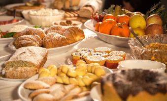 a large buffet table filled with a variety of desserts , including cakes , pastries , and fruits at Ottolire Resort