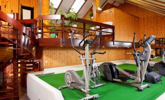 a gym with various exercise equipment , including stationary bikes and treadmills , in a wooden interior at Hotel Central