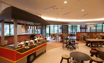 a modern hotel lobby with various seating options , including couches , chairs , and tables , as well as a buffet - style dining area at Hotel Cham Cham