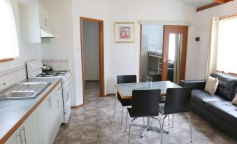 a kitchen with a dining table and chairs , as well as a living room area at Big4 Breeze Holiday Parks - Eildon