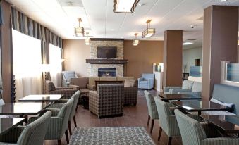 a spacious , well - lit lobby with comfortable seating areas , a fireplace , and a large flat - screen tv at Riverview Inn