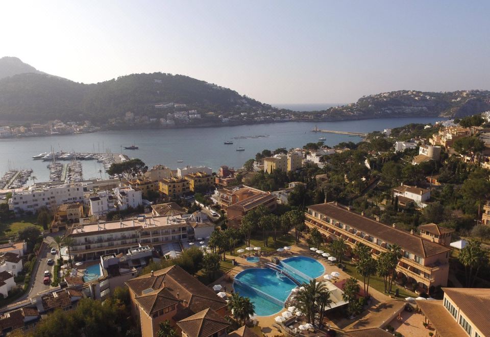 a bird 's eye view of a city with buildings , water , and a pool , taken from a high vantage point at Mon Port Hotel & Spa