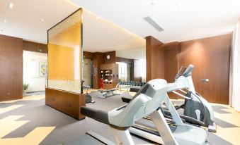A spacious room with a designated exercise area and additional equipment in the combined living and dining areas at Hampton by Hilton Ji'an