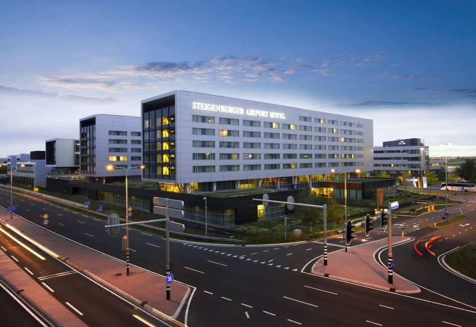 "a large building with a sign that says "" rem center "" is lit up at night" at Steigenberger Airport Hotel Amsterdam