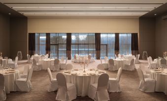 a large , elegant banquet hall with multiple round tables set for a formal event , each table having its own arrangement of white tablecloths at Sheraton Dubrovnik Riviera Hotel