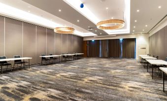 a large , empty conference room with multiple tables and chairs set up for meetings or events at Quality Hotel Rules Club Wagga