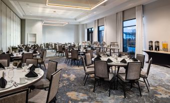 a large , well - lit conference room with multiple tables and chairs set up for a meeting or event at Crowne Plaza North Augusta