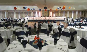 a large banquet hall is set up for a formal event , with multiple tables and chairs arranged for guests at Lakeside Resort & Conference Center