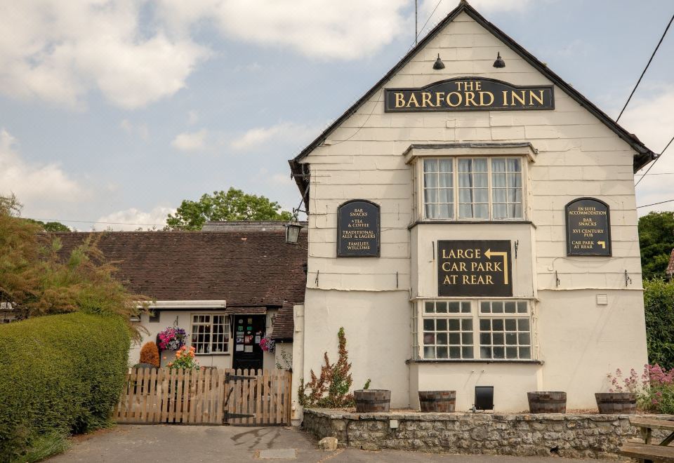 "a white building with a sign that says "" the barford inn "" and a large car park in front" at The Barford Inn