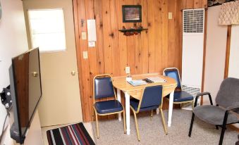 a wooden room with a table and chairs , a door , and a television on the wall at Betsie Riverside Resort