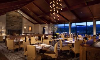 a large , well - lit dining room with multiple tables and chairs arranged for a group of people to enjoy a meal at Rosewood Sand Hill