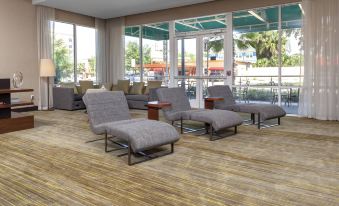 a room with several chairs and couches arranged in a lounge area , creating a comfortable and inviting atmosphere at Courtyard DeLand Historic Downtown