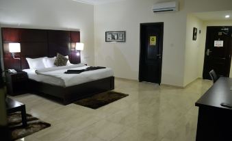 a large bedroom with a king - sized bed , a tv mounted on the wall , and a bathroom nearby at De Santos Hotel