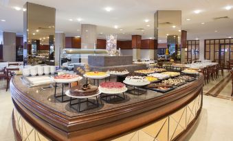 a large buffet table filled with a variety of food items , including meats , fruits , and desserts at Hipotels Flamenco
