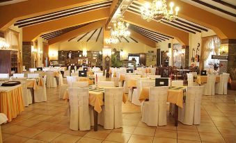a large dining room with multiple tables covered in white tablecloths , creating a festive atmosphere at Mythos