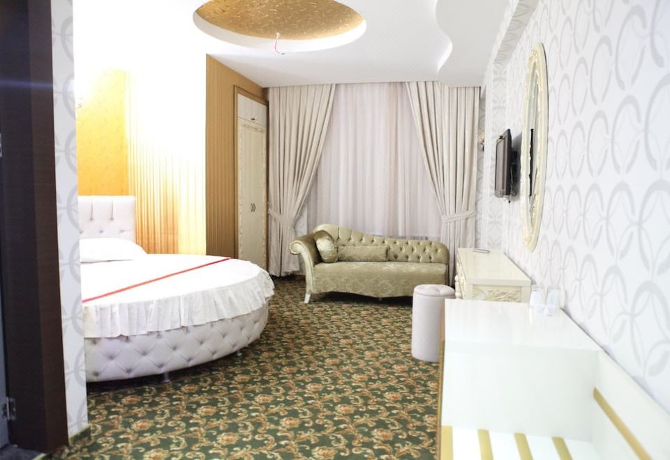 a modern hotel room with a large bed , couch , and tv , decorated in white and beige colors at Mostar Hotel