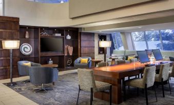 a modern hotel lobby with a large wooden desk and chairs , creating a comfortable seating area at Marriott Albuquerque