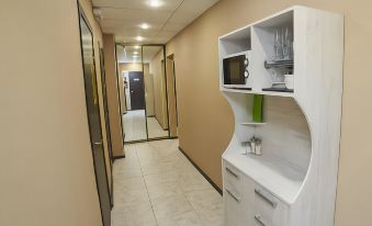 a long , narrow hallway with a white shelf on one side and a brown wall on the other at Luna Hotel