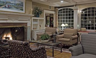 a spacious living room with multiple chairs and couches arranged around a fireplace , creating a cozy atmosphere at Stage Neck Inn