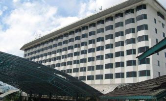 a large white hotel with many windows and a green canopy in front of it at Horison Ultima Bandung