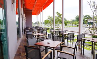 a restaurant patio with several tables and chairs , some of which are covered in red plastic sheets at Raia Hotel & Convention Centre Alor Setar