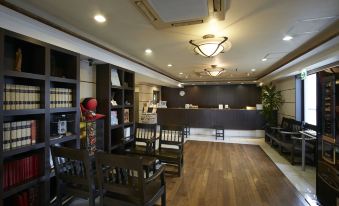 a spacious waiting area with wooden flooring , dark wood furniture , and a reception desk at Country Hotel Takayama