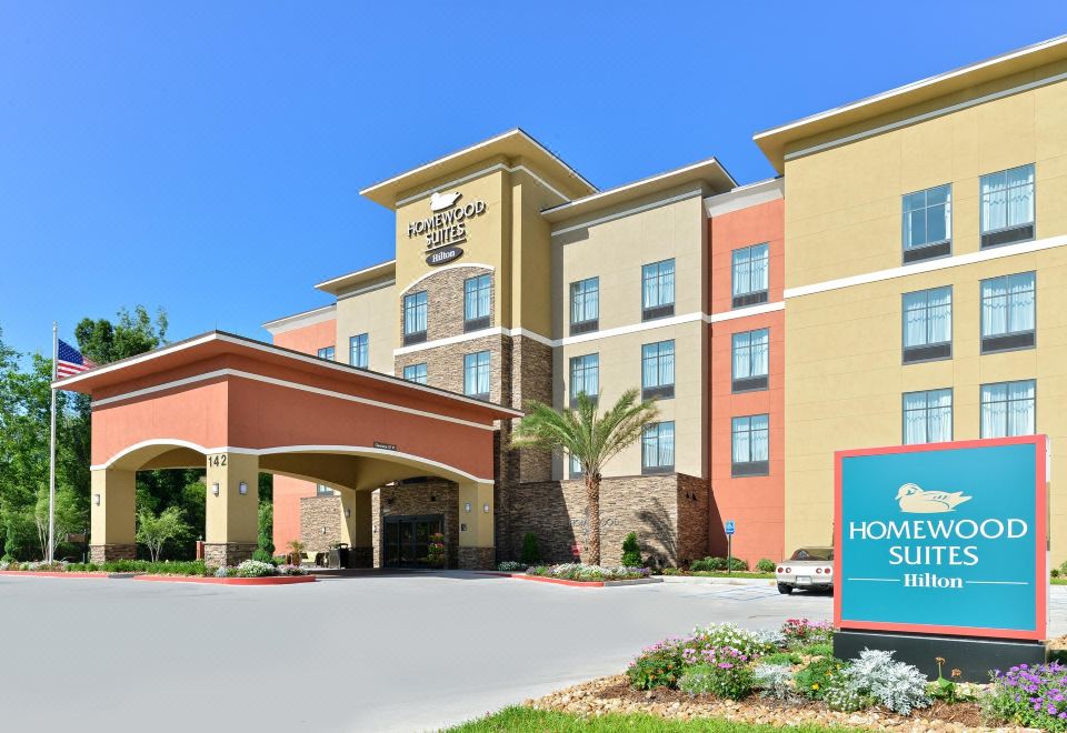 "a large hotel with a blue sign that says "" hampton inn & suites "" in front of it" at Homewood Suites by Hilton Houma