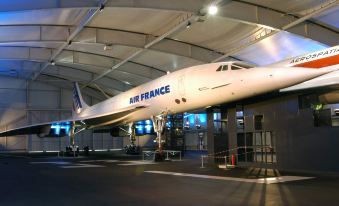"a white airplane with the words "" air france "" on its side is parked in an airport hangar" at AC Hotel Paris le Bourget Airport