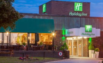 a holiday inn hotel at night , with its sign lit up and the awning open at Holiday Inn Leeds - Wakefield M1, Jct.40