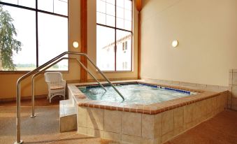 a large indoor hot tub surrounded by windows , allowing natural light to fill the space at Norfolk Lodge & Suites, Ascend Hotel Collection