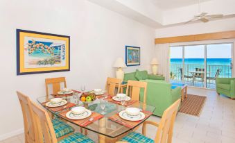 a dining room with a glass table and chairs , along with a view of the ocean at Wyndham Reef Resort Grand Cayman