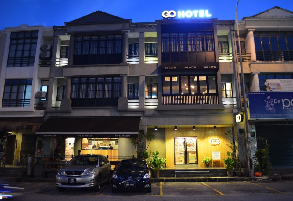 "a modern hotel building at night , with the name "" g 8 hotel "" prominently displayed on its facade" at Go Hotel