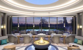 a modern living room with a large circular glass ceiling , surrounded by comfortable seating and a fire pit at Rockliffe Hall Hotel Golf & Spa