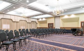 a large conference room with rows of chairs arranged in a semicircle , and a chandelier hanging from the ceiling at Quality Inn Festus