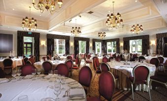 a large , elegant dining room with multiple tables and chairs arranged for a formal event at Macdonald Inchyra Hotel and Spa