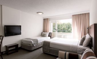 a hotel room with two beds , one on the left and one on the right side of the room at St Ives Apartments