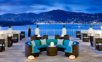 At night, there is a rooftop patio with tables and chairs that overlooks an outdoor seating area at The Westin Beach Resort & Spa at The Westin Beach Resort & Spa at Frenchman’s Reef