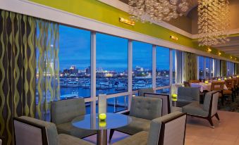 a restaurant with a view of a city skyline , featuring several tables and chairs set up for patrons at Golden Nugget