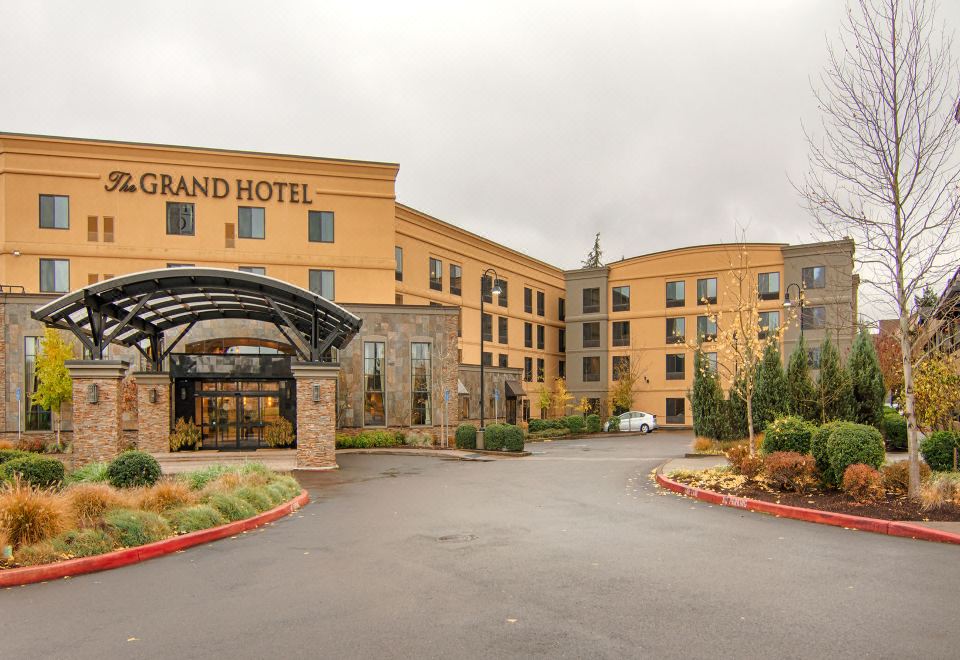 the grand hotel entrance is shown with a yellow building and an arched gate in the background at Grand Hotel at Bridgeport