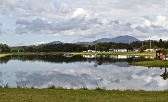 a serene landscape of a lake with mountains in the background and a building in the foreground at Stoney Park