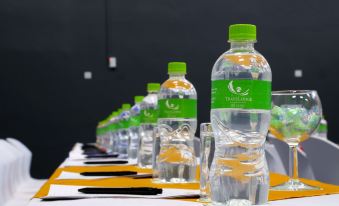a long table with numerous bottles of water placed on it , ready for use during a meeting or event at Travelodge Kasane