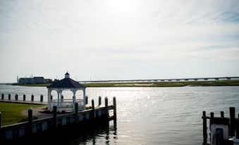 a serene view of a white gazebo on the waterfront , with a bridge in the background at Key West Cottages