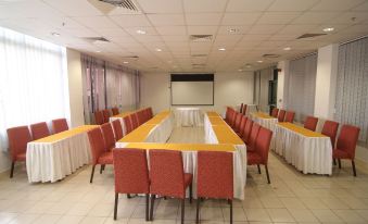 a conference room set up for a meeting with chairs arranged in a semicircle around a long table at Gold Crest Hotel