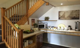 a kitchen with wooden cabinets , a counter , and a staircase leading to the second floor at Redwings Lodge Rutland