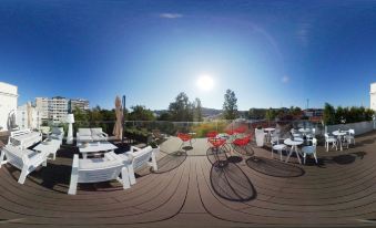 a rooftop patio with a variety of outdoor furniture , including chairs , tables , and umbrellas , as well as bicycles at Thomar Boutique Hotel