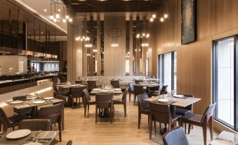 a large dining room with wooden tables and chairs arranged for a group of people to enjoy a meal together at Hotel Valletta