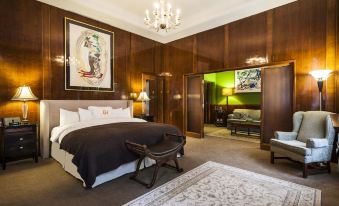 a spacious bedroom with a king - sized bed , a television , and a bathroom visible through an open door at LHotel